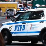 NYPD police car on a city street scene.