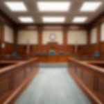 Empty courthouse courtroom with wooden benches and chairs.