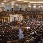 People seated in a large governmental assembly hall