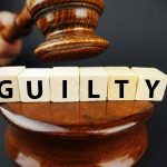 Gavel striking blocks spelling guilty