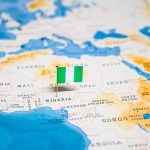 Flag pin marking Nigeria on Africa map.