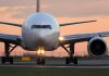 Airplane on runway during sunset with lights on
