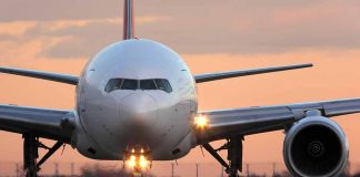 Airplane on runway during sunset with lights on