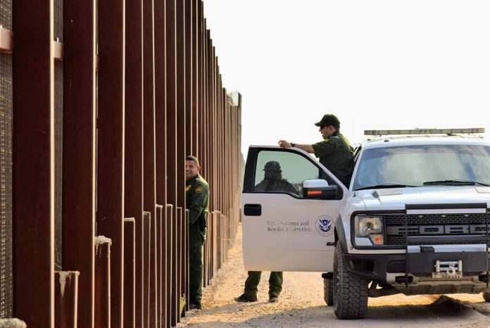1545833798 featured image Border patrol agents near a tall metal fence