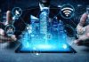 Holographic city above tablet with technology icons