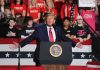 Person speaking at podium with crowd behind them