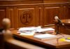Wooden courtroom desk with papers and a microphone