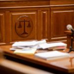 Wooden courtroom desk with papers and a microphone