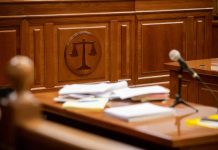 Wooden courtroom desk with papers and a microphone
