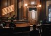 Judge presiding over courtroom with people seated