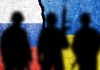 Silhouettes against split Russian and Ukrainian flags