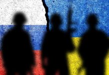 Silhouettes against split Russian and Ukrainian flags