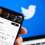 Twitter profile on smartphone screen with Twitter logo background