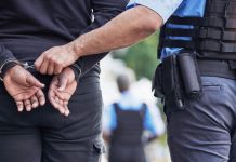 Police officer handcuffing person outdoors