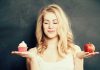Woman holding a cupcake and an apple