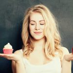 Woman holding a cupcake and an apple