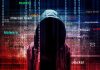 Hooded figure with digital security terms background