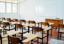 Empty classroom with desks chairs and whiteboard