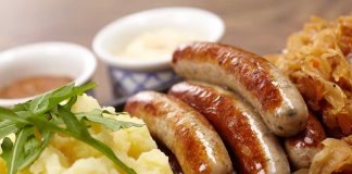 Sausages mashed potatoes sauerkraut and sauces on plate