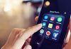 Finger tapping smartphone social media app icons