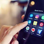 Finger tapping smartphone social media app icons