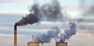 Industrial plant emitting black smoke into the sky