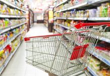 Empty shopping cart in grocery store aisle