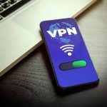 Smartphone displaying VPN app beside a laptop