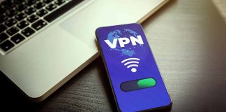 Smartphone displaying VPN app beside a laptop