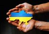 Hands holding Ukraine map with flag design