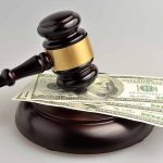 Gavel resting on hundred-dollar bills
