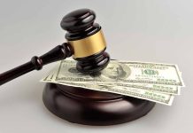 Gavel resting on hundred-dollar bills
