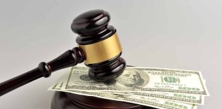Gavel resting on hundred-dollar bills