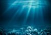 Sunlight beams illuminating ocean coral reef underwater scene