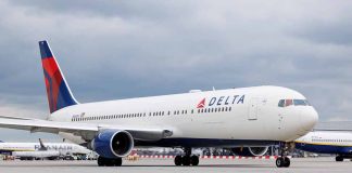 Delta Airlines airplane on airport runway cloudy sky