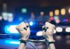 Hands in handcuffs in front of police cars