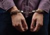 Person wearing handcuffs on their wrists