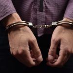 Person wearing handcuffs on their wrists