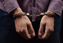 Person wearing handcuffs on their wrists