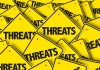 Yellow warning signs with the word THREATS