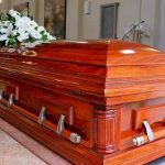 Wooden casket with white flowers in a funeral home