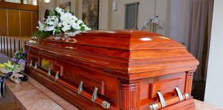 Wooden casket with white flowers in a funeral home