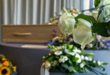 White roses in front of a casket.