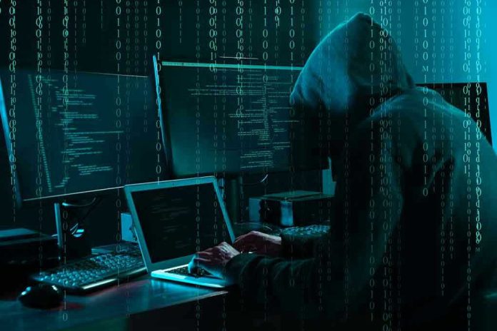 1703023243 Hacker in dark room surrounded by computer screens
