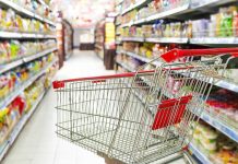 Empty shopping cart in grocery store aisle