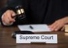 Judge with gavel and Supreme Court nameplate