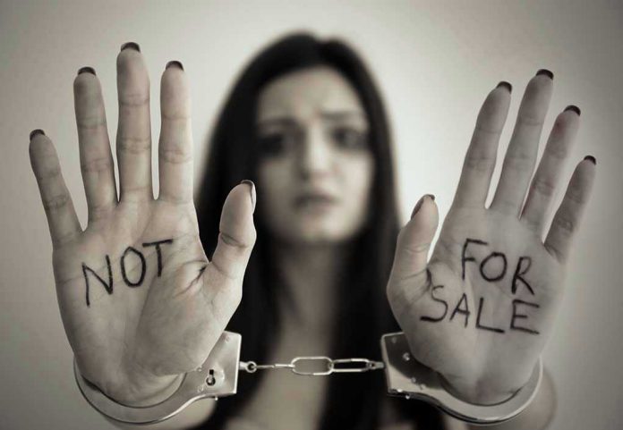 631031339 Handcuffed woman shows NOT FOR SALE on her palms