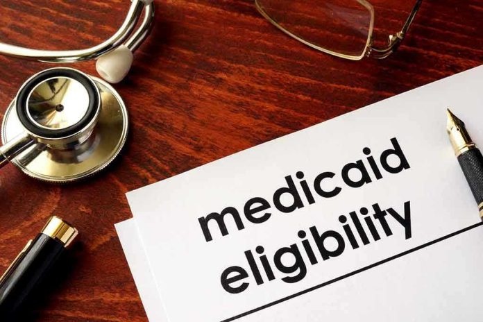 640488934 Stethoscope pen document about Medicaid eligibility on table