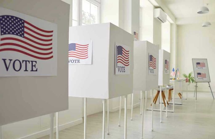 2367560637 Voting booths with American flag and VOTE signs.