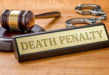Gavel, handcuffs, and Death Penalty sign on desk.